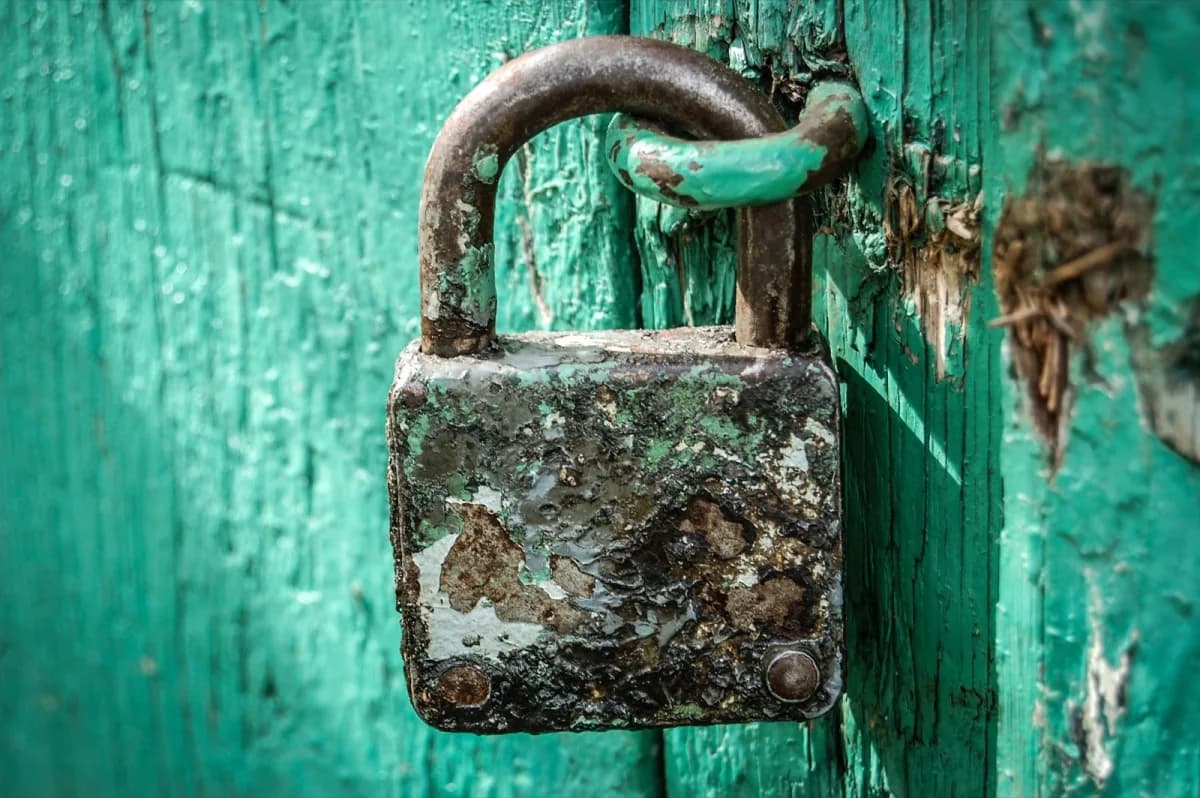 Un cadenas fermé sur une porte ancienne pour évoquer la protection et la vigilance
